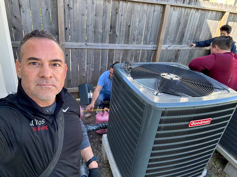 J. Tullos Services team installing a new Goodman air conditioning unit