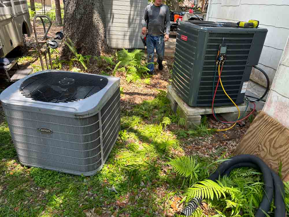 J. Tullos Services technician servicing outdoor AC condenser units with gauges connected